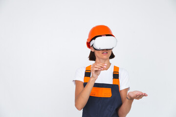 Pretty woman engineer in building protective helmet on white background in virtual reality glasses