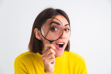 Pretty woman in yellow sweater on white background held magnifier happy positive playful - obrazy, fototapety, plakaty