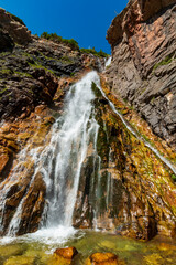 clear waters of Apikuni Falls in Many Glacier area in Glacier National park in Montana during summer.