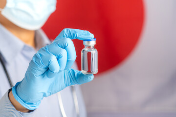 The doctor holding a vaccine bottle prepares vaccination against the background of the Japanese...