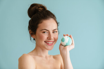 Half-naked brunette woman smiling while posing bath bomb