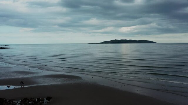 Cloudy evening  Donabate beach in summer, Dublin, Ireland.
Aerial view over beach landscape and revealing the Irish sea and Lambay Island.