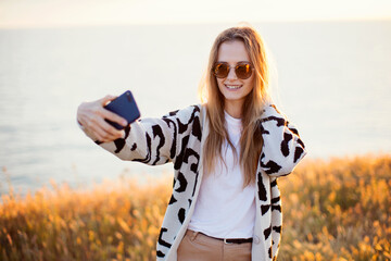 Portrait of a beautiful woman making selfie outdoor.