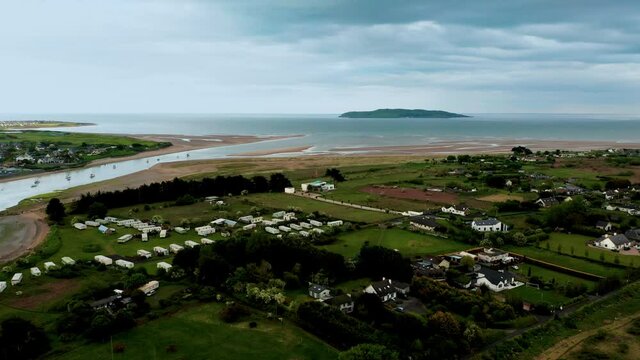 Aerial drone view over Irish coastal village and Lambay Island at sunset.Textured landscape and water reflections at sunset.Rogerstown Estuary, Donabate, Dublin Co. 