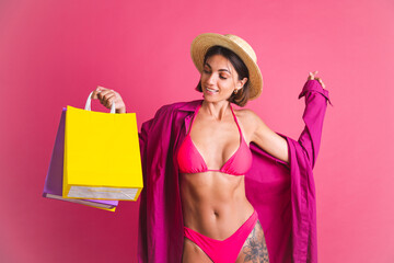 Beautiful fit tanned sporty woman in shirt and bikini with colorful shopping bags happy excited on...