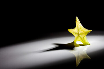 Light through a slice star fruit isolated on black background.