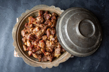 Muslims Traditional Sacrifice holiday food lamb, Turkish roasted meat in copper pot on table top. Turkish Kavurma.