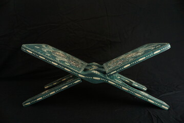A photo of a buffer / standing of the Islamic holy book in dark green with an interesting motif....