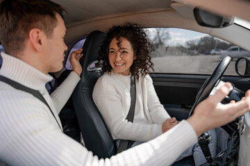Man talking something to curly woman in car