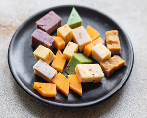 cheese assortment variation aged cheeses basil, lavender, fenugreek, chili, baked milk, turmeric, carrot healthy food meal copy space food background rustic 