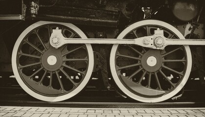 Steel wheels of a vintage steam locomotive in sepia style