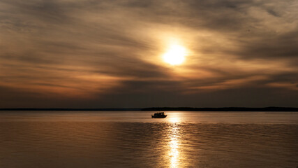 A boat travels across the horizon on a large lake in Oklahoma