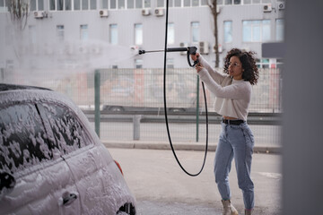 Girl wash personal car on self-service car wash