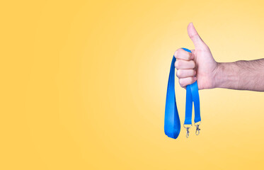  hand holding with like Blue Lanyards neck strap with Metal Lobster Clip. isolated over orange background. Space for text.