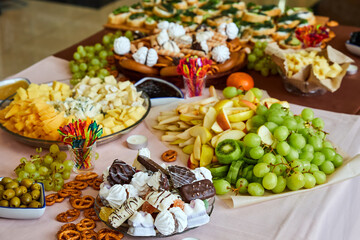 Table with fruits, sweets and cheese. Close-up, selective focus