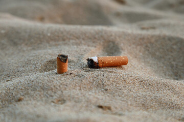 Mégots de cigarette dans le sable d'une plage