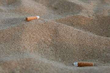 Mégots de cigarette dans le sable d'une plage
