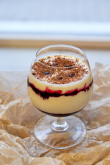 Creamy dessert with jam and chocolate in a glass. Close-up, selective focus