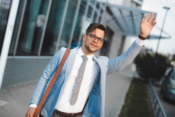 Handsome businessman catching taxi in city