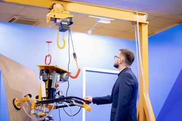 Vacuum conveyor to move flat load in factory uses Worker engineer, production industry optimization concept