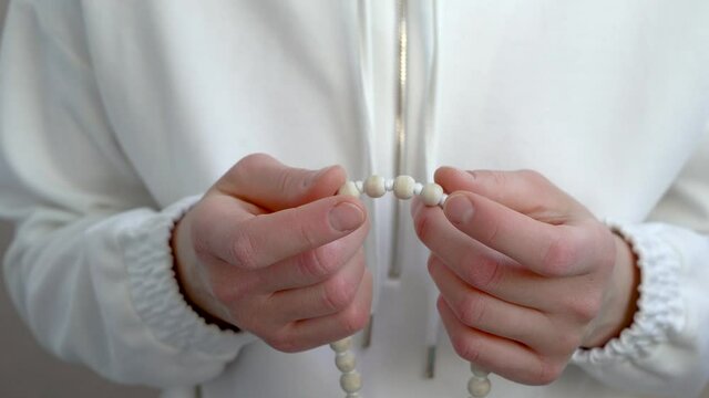 Japa meditation on the rosary. Hand-picking of wooden beads in close-up.