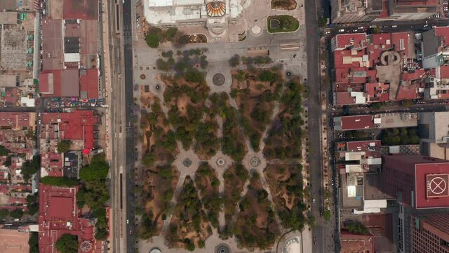 Aerial birds eye overhead top down panning view of public urban park Alameda Central and Palacio de Bellas Artes museum building. Mexico city, Mexico.