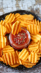 Chips on a plate and red sauce.