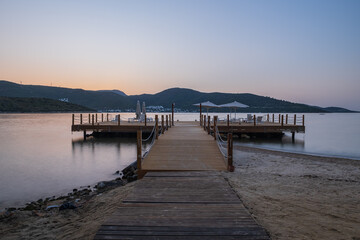 Fototapeta premium sunset over bay in Aegean sea. Torba, Bodrum, Turkey. October 2020. Long exposure picture with pier, jetty