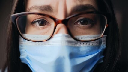 Sad almost crying woman in glasses fighting with headache and stress wearing face mask