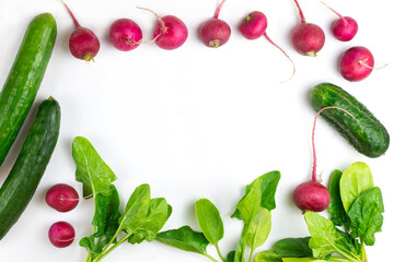 Preparation of spring salad from cucumber, radish and spinach. Salad ingredients on a white background. A place for text. View from above. concept