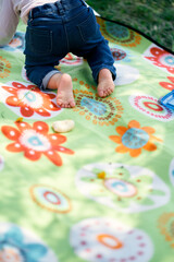 Little girl is crawling on a colored blanket. Close-up