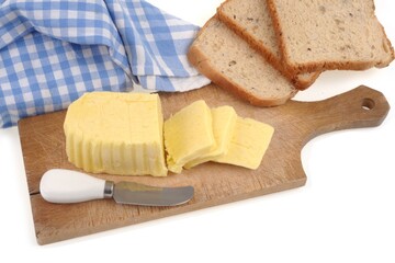 Beurre tranché sur une planche à découper avec un couteau à côté de tranches de pain de mie en gros plan sur fond blanc