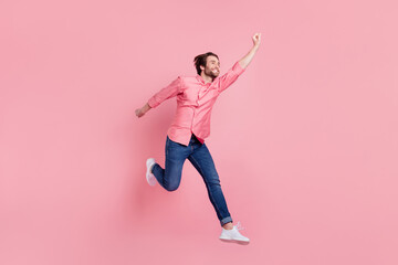 Fototapeta na wymiar Full length body size view of attractive carefree cheerful guy jumping having fun success isolated over pink pastel color background