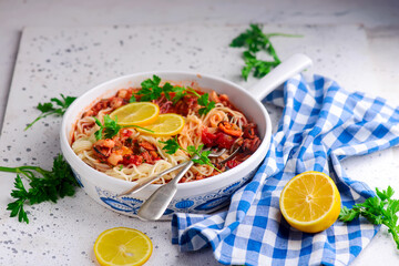 Italian seafood pasta in a white frying pan.top view