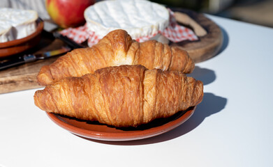 French breakfast with fresh baked croissants and cheeses from Normandy, camembert and neufchatel served outdoor with nice city view