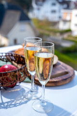 Drinking of brut champagne sparkling wine in flute glasses on outdoor bistro terrace in France