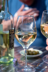 Drinking of dry white wine on open terrace in spring garden