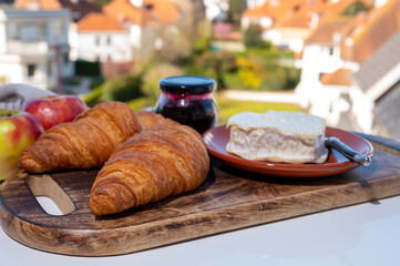 French breakfast with fresh baked croissants and cheeses from Normandy, camembert and neufchatel served outdoor with nice city view