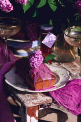 Lavender glaze cake on a table in a spring garden..style vintage