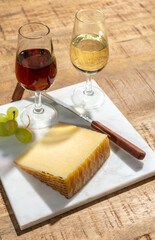 Cheese collection, piece of spanisch hard manchego cheese made in La Mancha region from sheep milk and glasses of sherry wine
