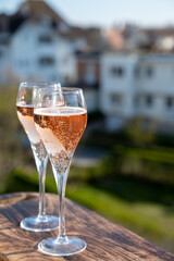 Drinking of rose champagne sparkling wine from flute glasses on outdoor terrace in France