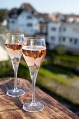 Drinking of rose champagne sparkling wine from flute glasses on outdoor terrace in France