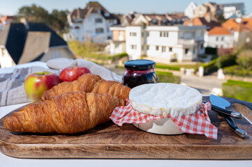 Obraz na płótnie Canvas French breakfast with fresh baked croissants and cheeses from Normandy, camembert and neufchatel served outdoor with nice city view
