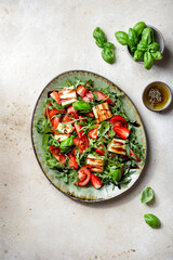 salad with strawberries, tomatoes and halloumi cheese