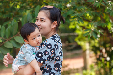 attractive woman carrying little baby boy