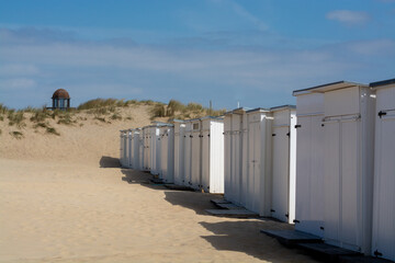 Obraz na płótnie Canvas White beach huts on yellow sandy beach in small Belgian town Knokke-Heist, luxury vacation destination, summer holidays