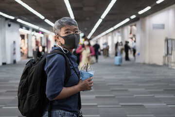 Smart Asian Woman with glasses and face masks prevent COVID-19 virus disease at airport terminal for boarding. Looking Camera serious while Cancel flights stop, Lifestyle traveler in Lockdown travel