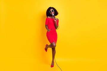 Fototapeta na wymiar Full size photo of young beautiful gorgeous happy afro girl in sunglasses singing karaoke isolated on yellow color background