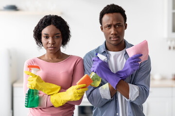 Comic black man and woman holding spray bottles as guns
