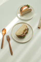 Chicken salad sandwich with lettuce on whole wheat bread sliced on a plate.